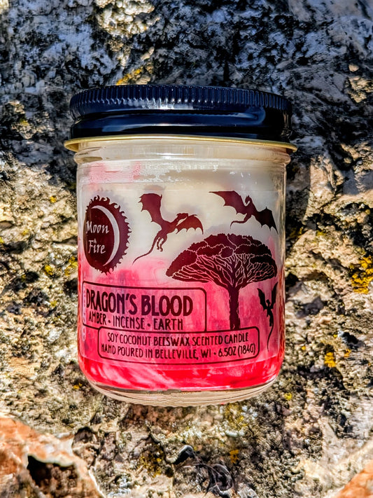 Jar of 'Dragon's Blood' candle with Moonfire branding on a textured stone surface