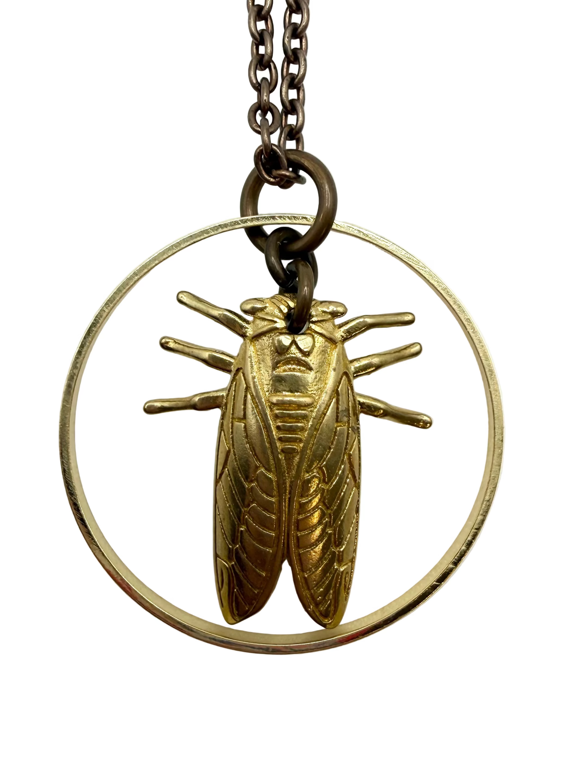 Gold cicada pendant on a white background