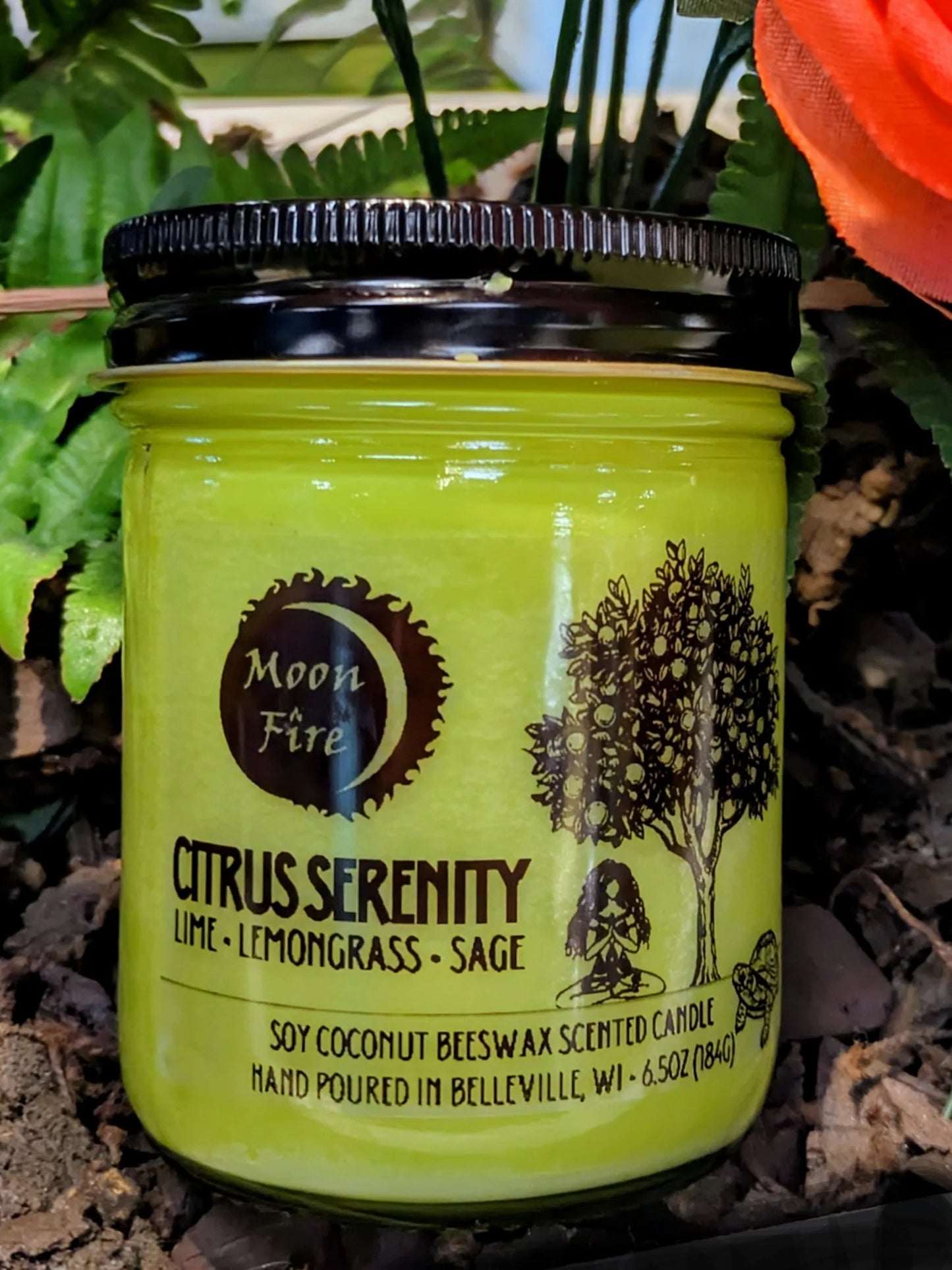Green candle jar labeled 'Citrus Serenity' with 'Moon Fire' branding on a natural background.