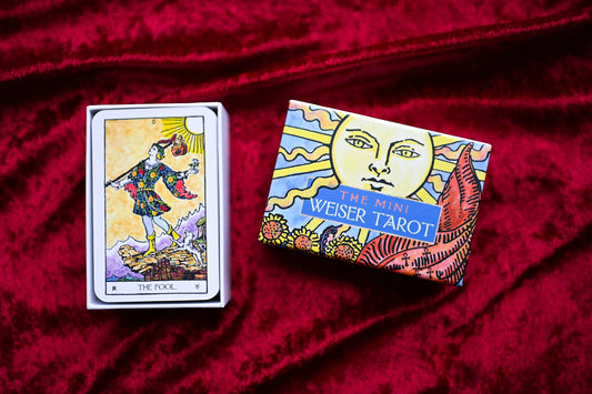 Mini Weiser Tarot box and card on a red fabric background